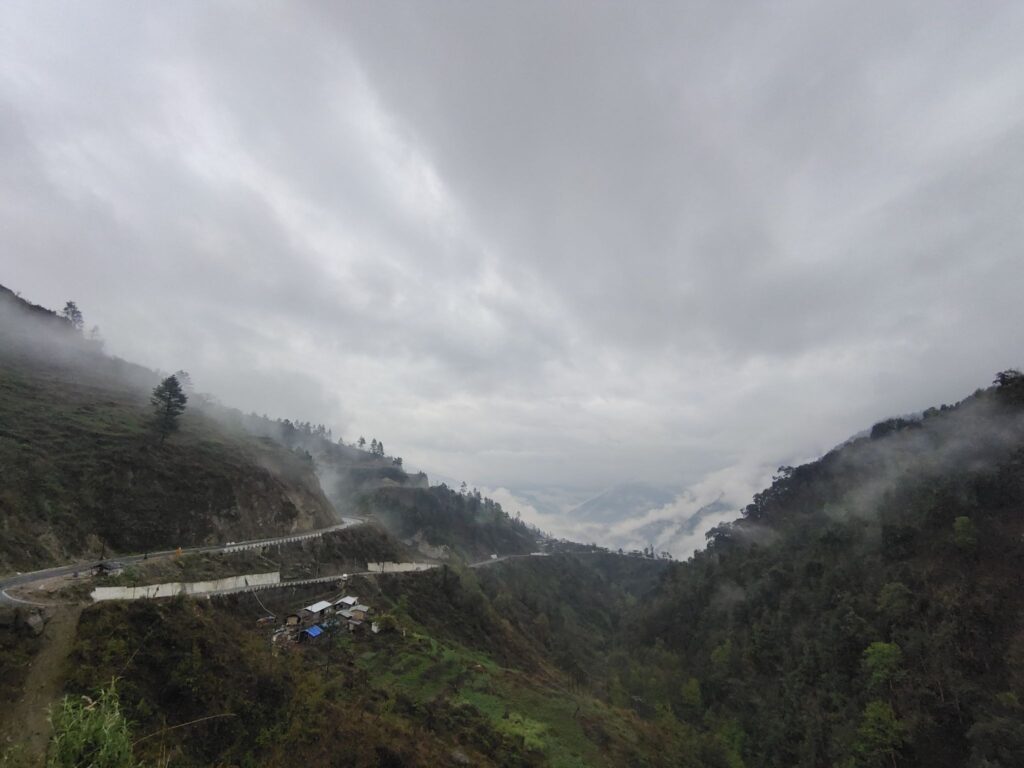 River bend and terraced fields in Dirang/Sangti Valley with green slopes.