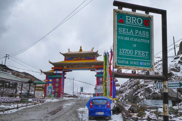 Road crew and traffic moving slowly near a high-mountain pass checkpost.